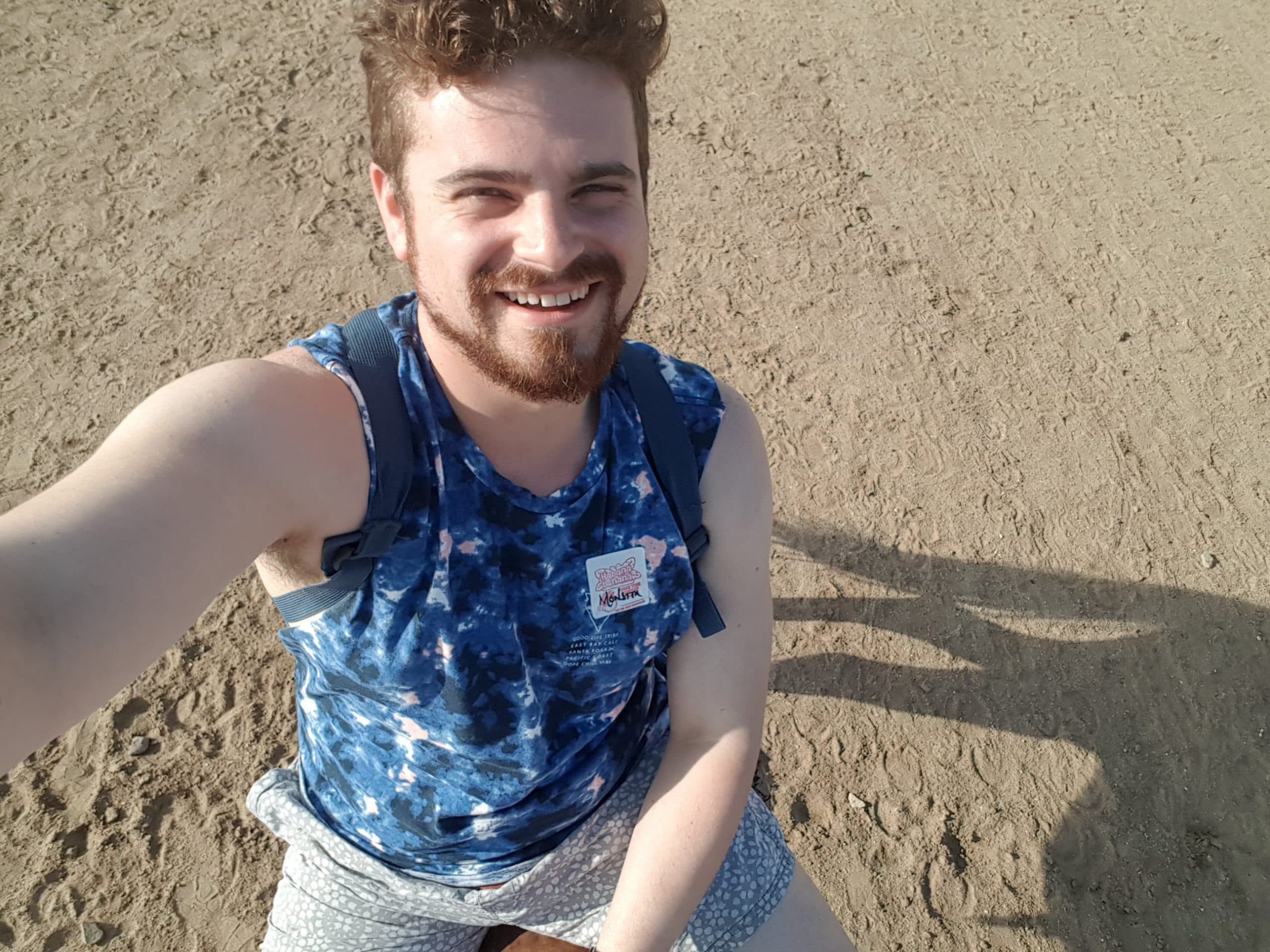 Nathan smiling while on a beach riding a horse