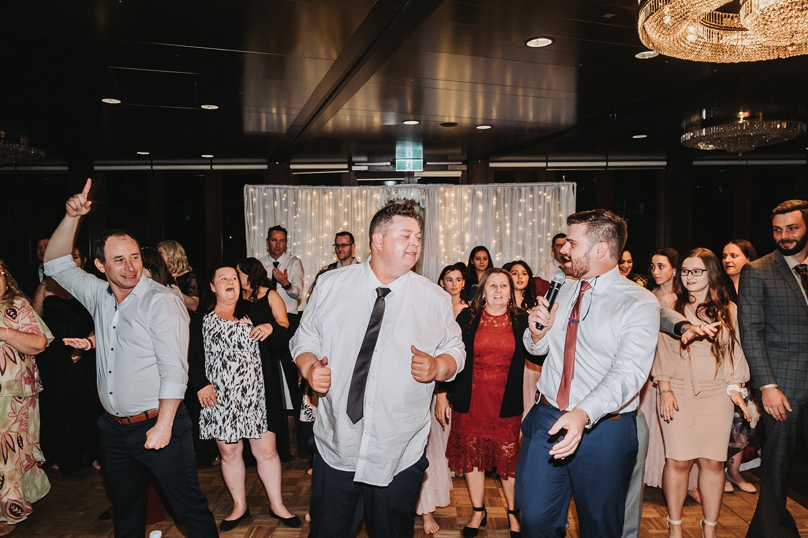 A group of wedding guests dancing in rows on the dancefloor