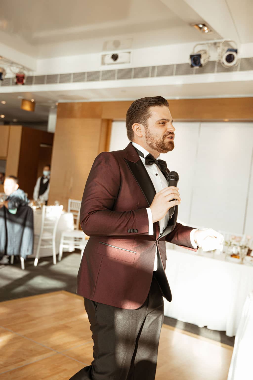 Nathan Cassar in a red jacket introducing a wedding