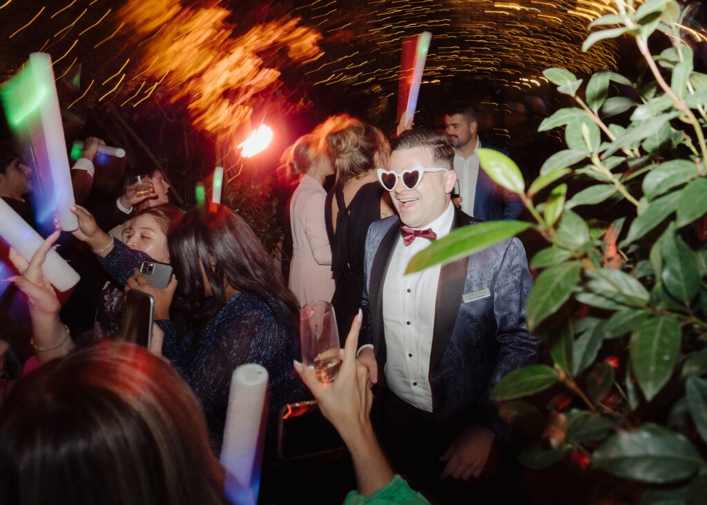 Nathan Cassar Master of Ceremonies in the centre of a packed dancefloor with white sunglasses on