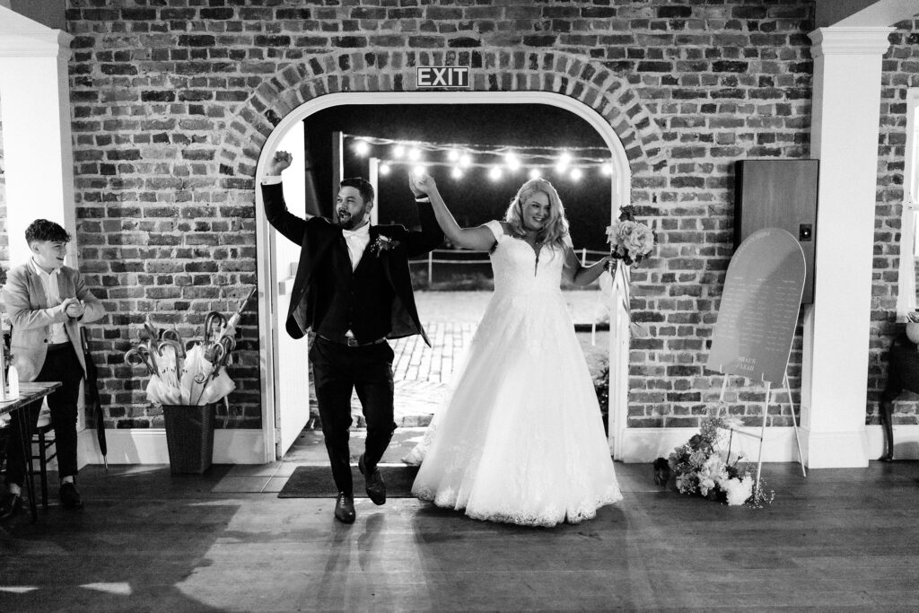 Newlyweds Leah & Shaun joining hands as they as enter their reception to epic wedding music