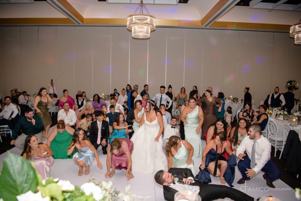 Nathan Cassar Master of Ceremonies leading a line dance segment during a lavish wedding at Miramare Gardens and on the floor while everyone has a great time