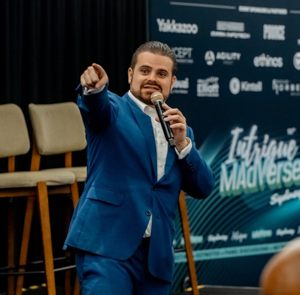 Nathan Cassar, Wedding & Corporate Master of Ceremony in blue suit speaking at conference stage