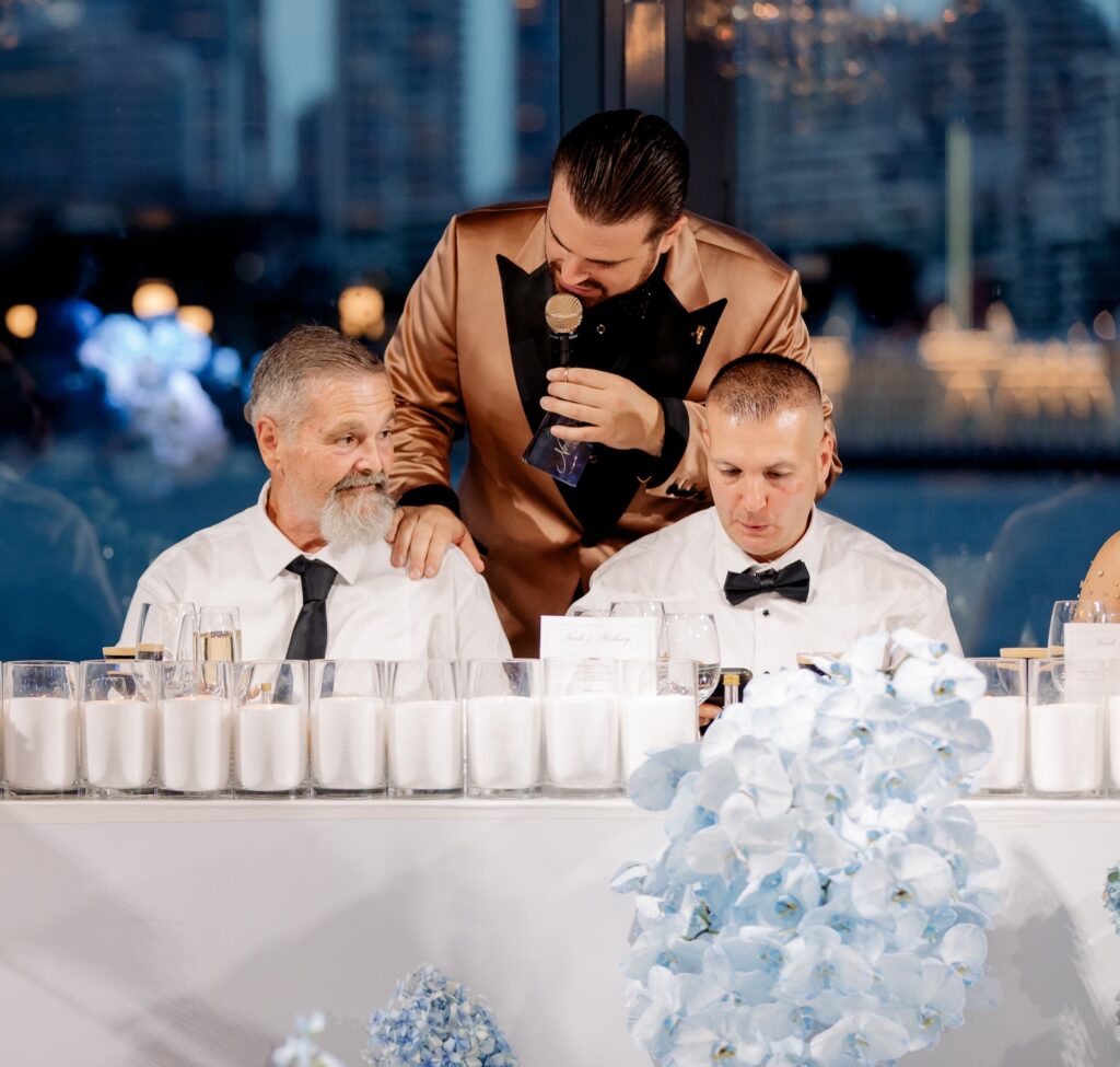 Man giving speech at elegant wedding reception table