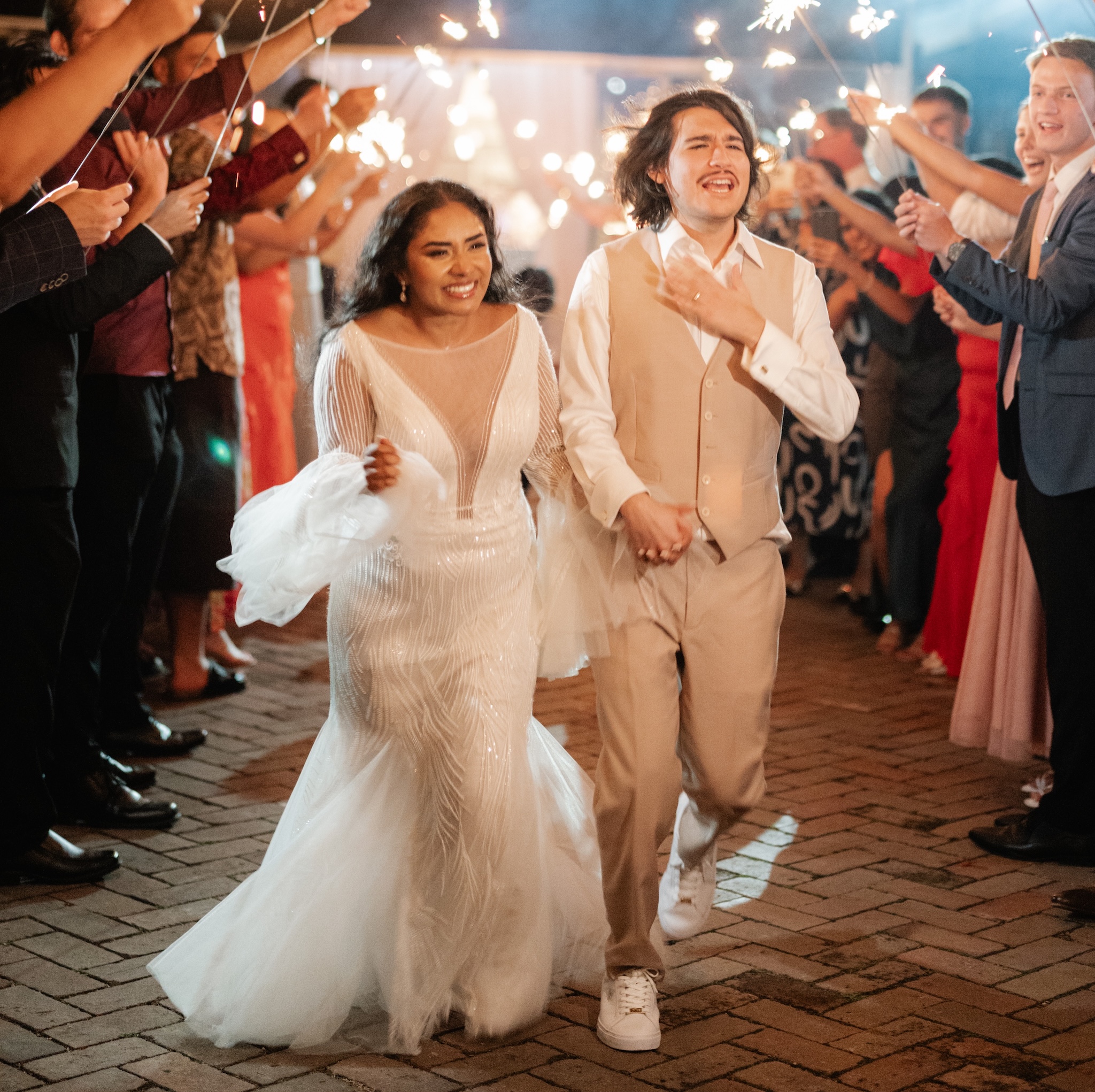 Bride and groom exit wedding under sparklers