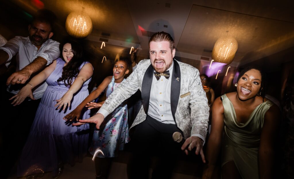 Guests dancing energetically at lively wedding reception party