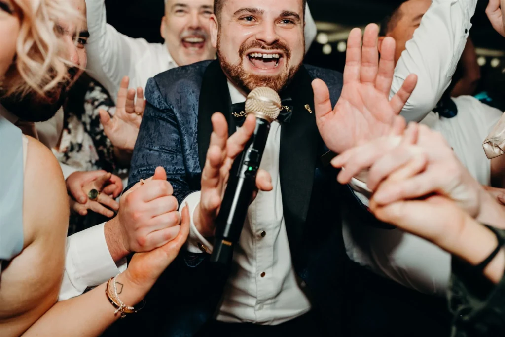 Man singing into microphone at lively party