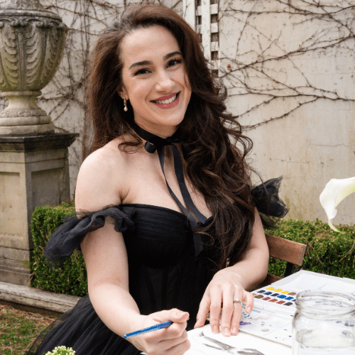 Smiling woman painting outdoors in black dress