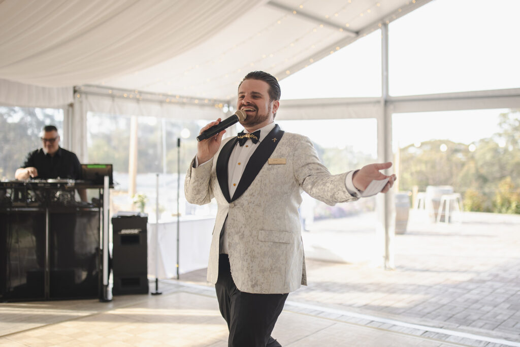 Wedding MC, Nathan Cassar speaking under marquee with DJ