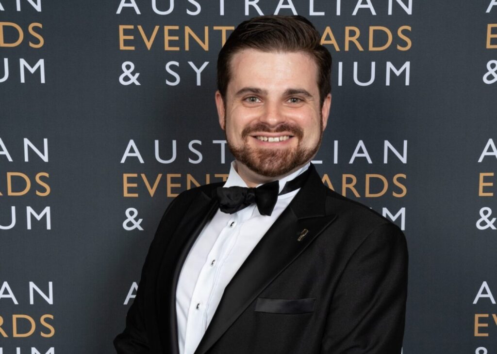 Man in tuxedo at Australian Events Awards backdrop