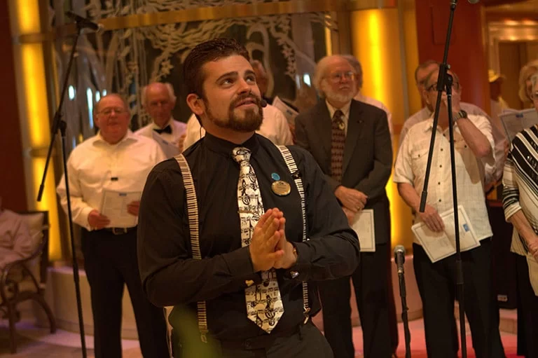 Man clasping hands before choir in warm hall