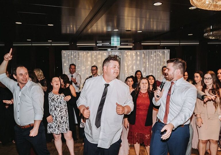 Nathan Cassar, MC dancing in front of rows of people at a wedding